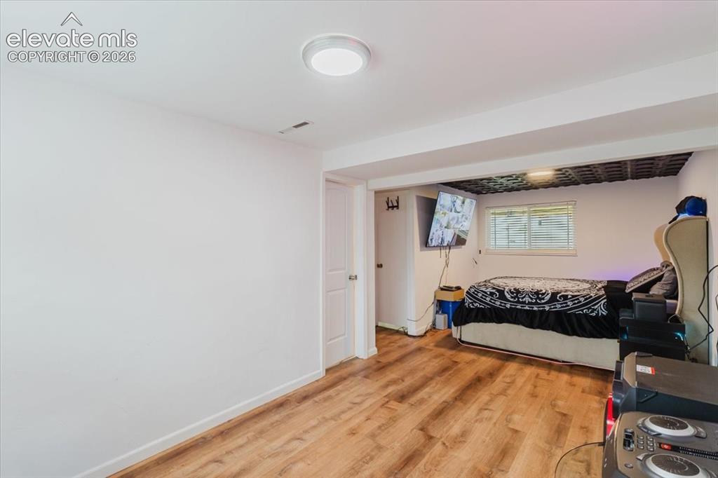 Image 17 of 50: Interior space featuring wood-finish flooring, white walls, and a white cei