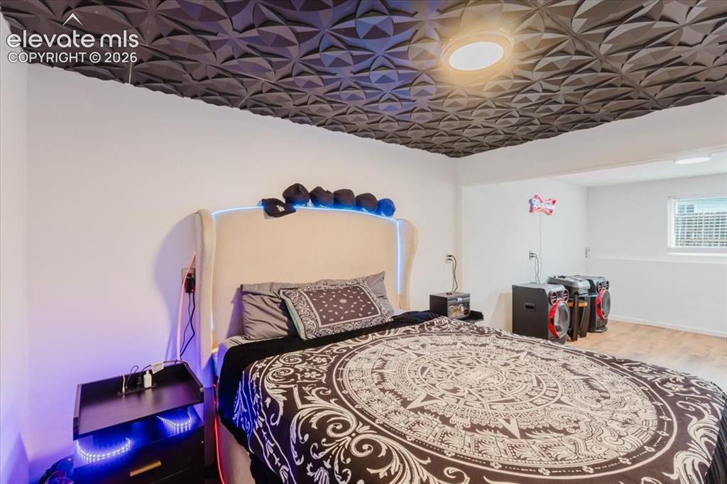 Image 19 of 50: Bedroom featuring a dimensional dark ceiling, recessed lighting, white wall