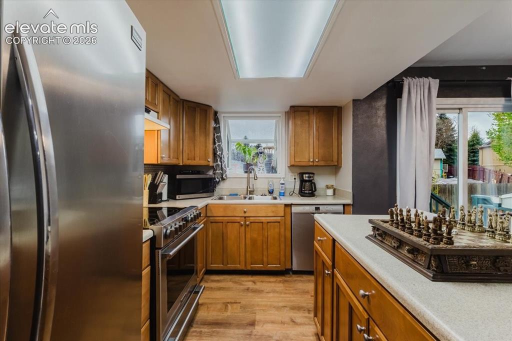 Image 45 of 50: Kitchen featuring stainless steel appliances, wood-finish flooring, a doubl