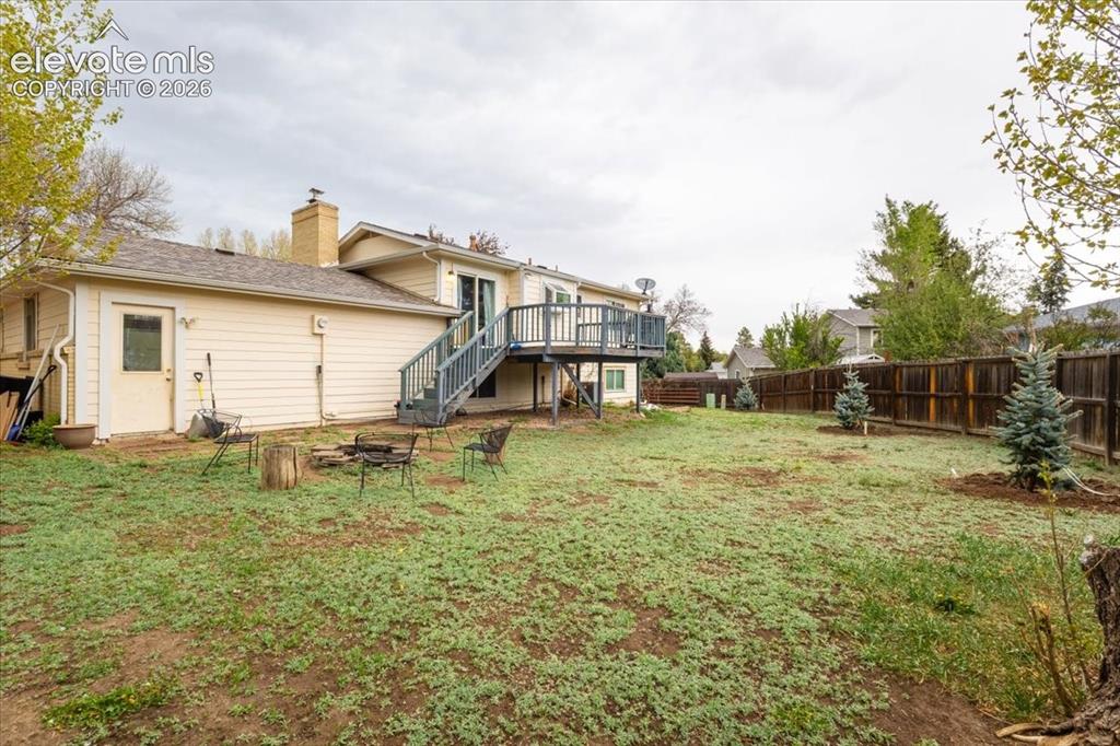 Image 46 of 50: Spacious backyard featuring a multi-level deck with stairs, a privacy fence