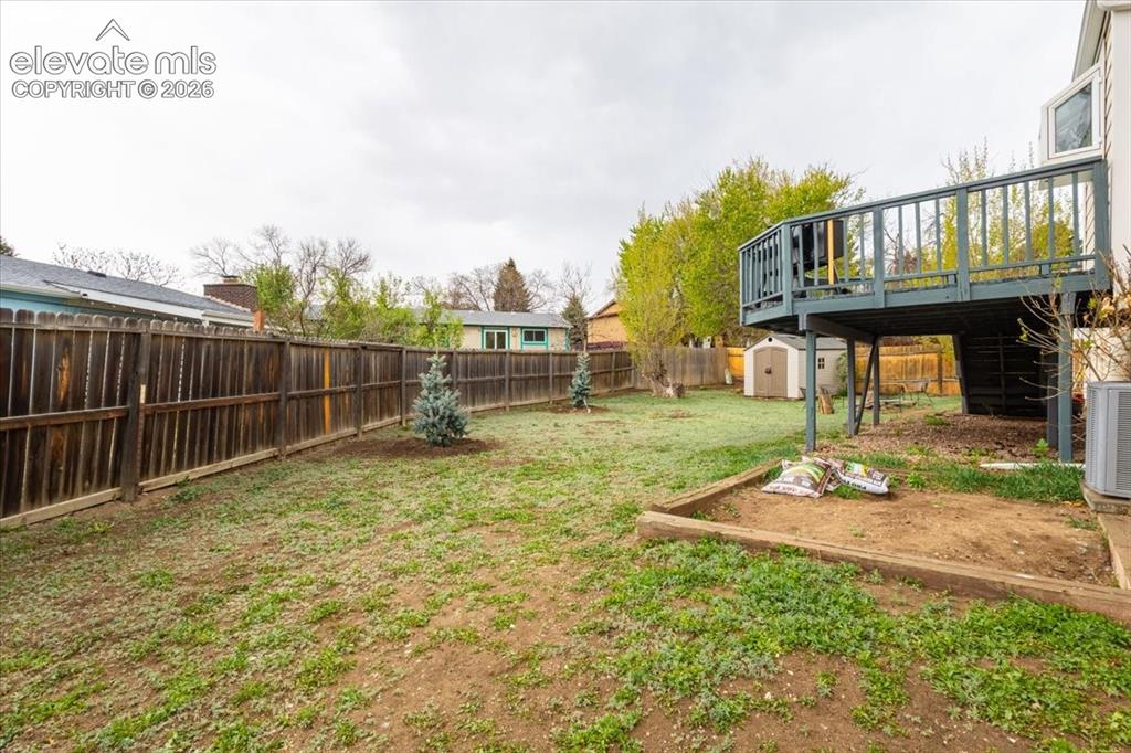 Image 48 of 50: Expansive backyard featuring a wood fence, established trees, and a raised