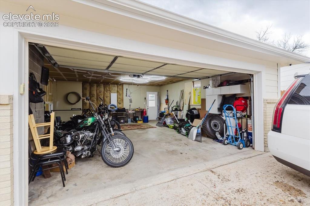 Image 5 of 50: Spacious garage featuring concrete flooring and exposed wall studs