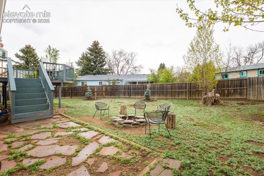 Image 50 of 50: Spacious backyard featuring a wooden privacy fence, a multi-level wooden de