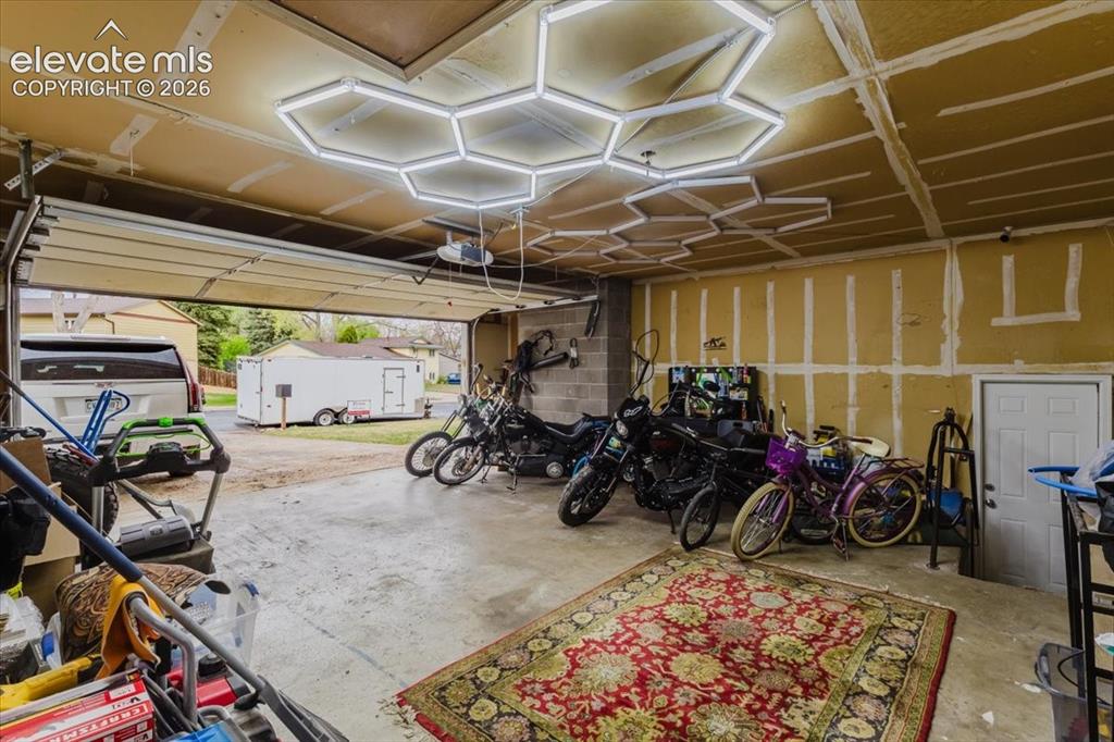 Image 7 of 50: Spacious garage featuring a concrete floor, overhead garage door, and a ded