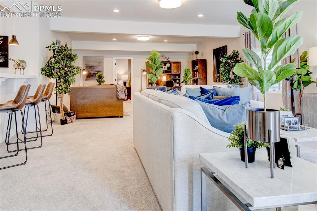 Image 14 of 20: Living area featuring beam ceiling, recessed lighting, and light carpet
