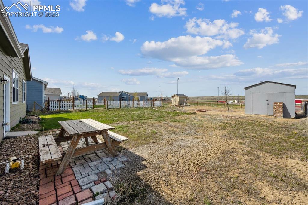 Image 19 of 25: View of yard with fence, an outbuilding, a patio, and a storage shed