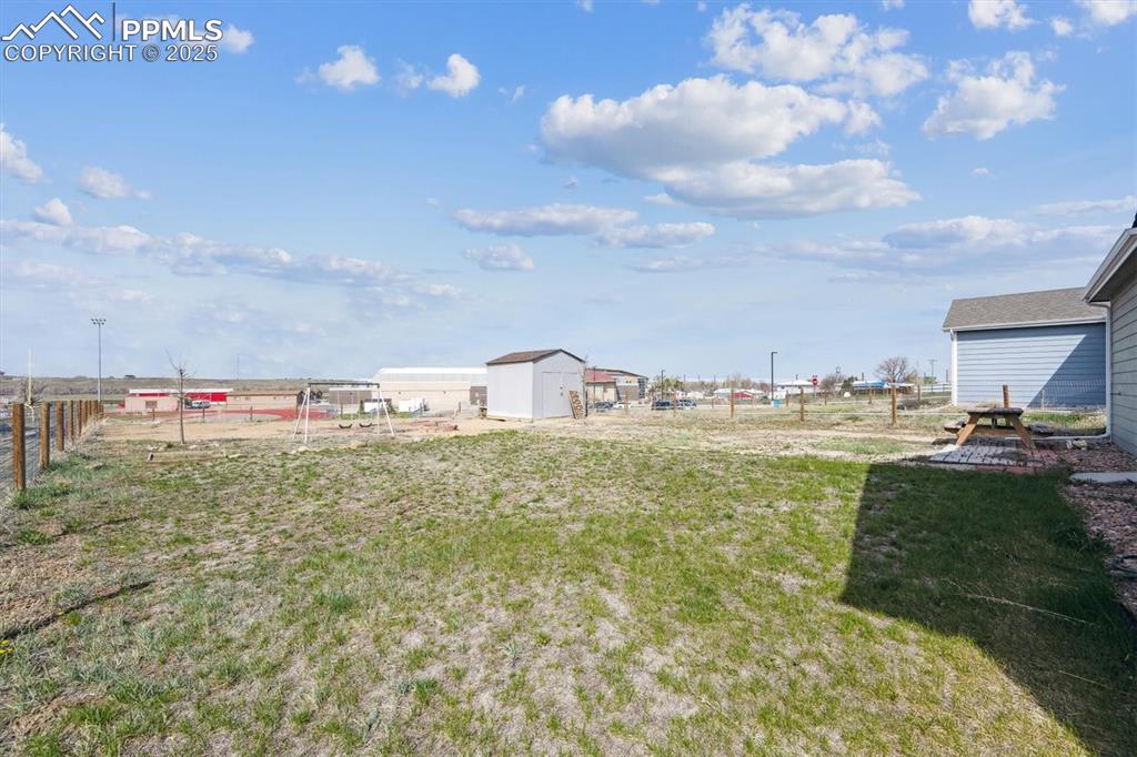 Image 21 of 25: View of yard with an outdoor structure, fence, and a shed