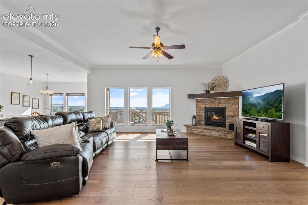 Image 11 of 50: Spacious living area featuring large windows, wood-finish flooring, a stone