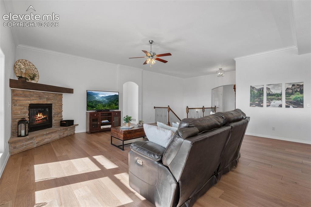 Image 13 of 50: Spacious living room featuring wood-finish flooring, a stone fireplace with