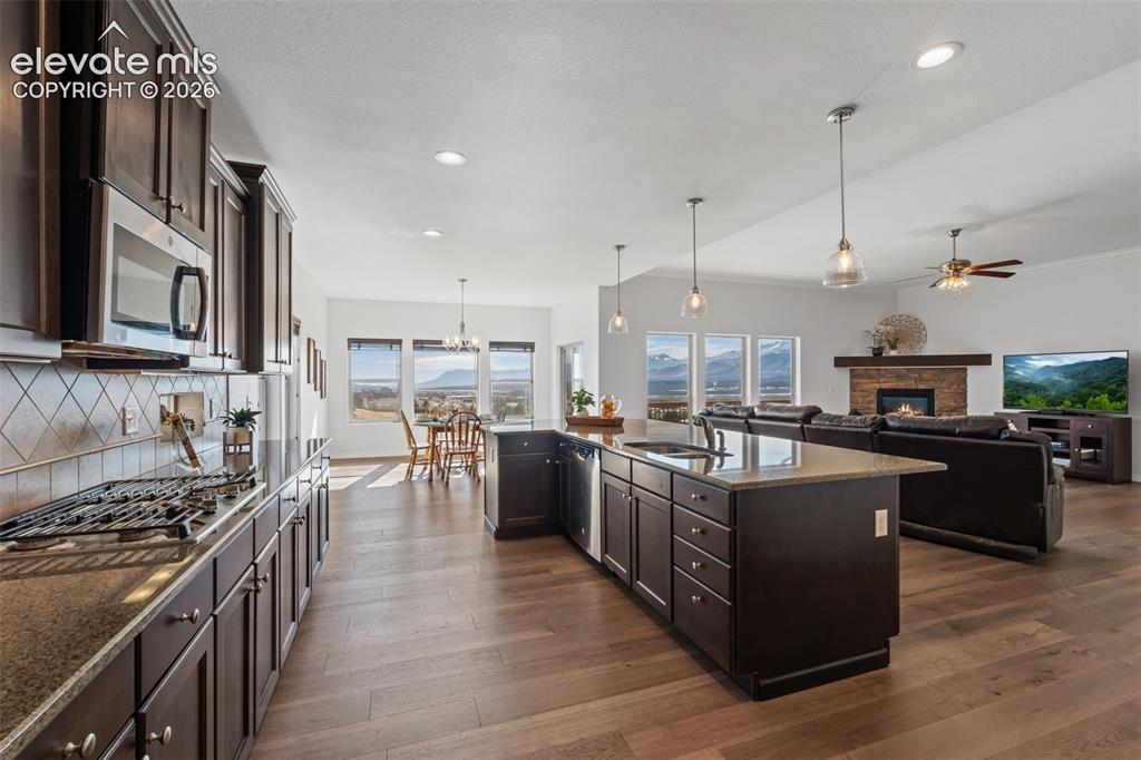 Image 18 of 50: Open-concept kitchen featuring wood-finish flooring, dark wood cabinetry, a