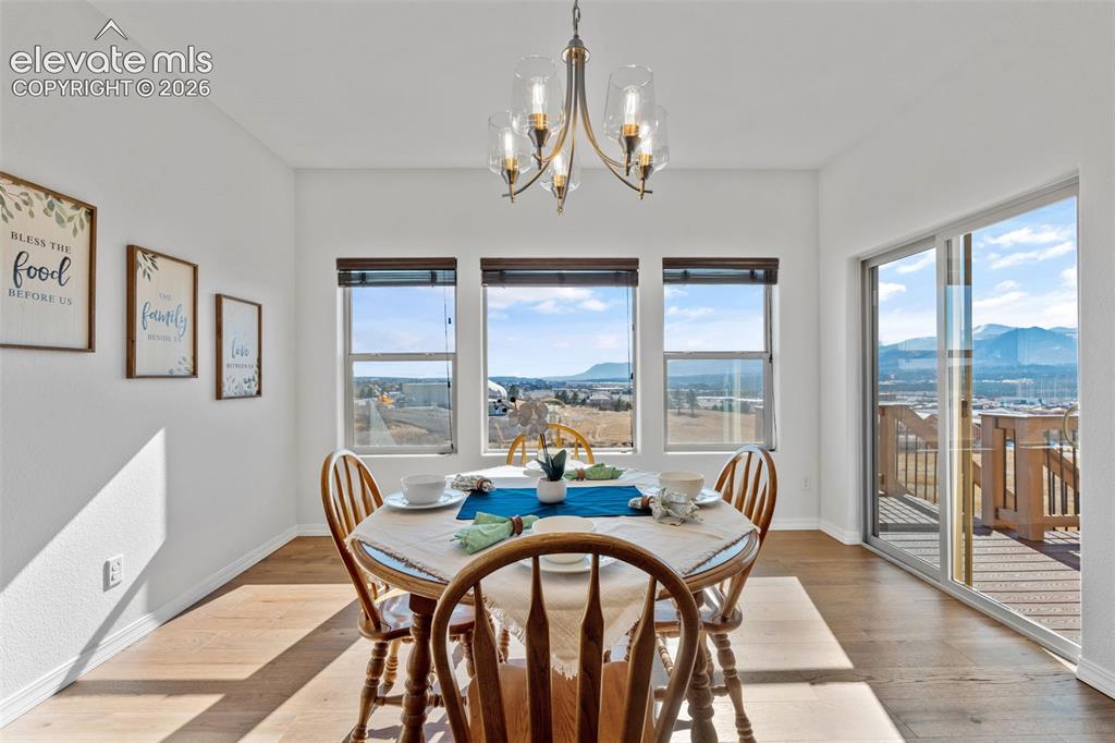 Image 22 of 50: Dining area featuring wood-finish flooring, a contemporary chandelier, and 