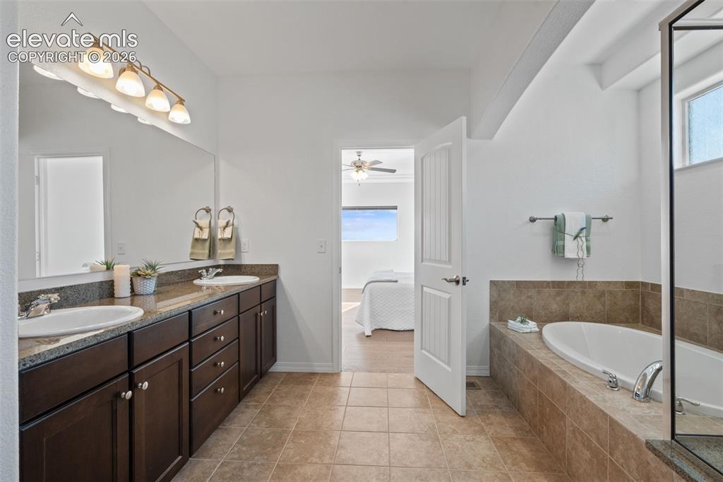 Image 32 of 50: Spacious bathroom featuring a double vanity with ample cabinetry, a large m