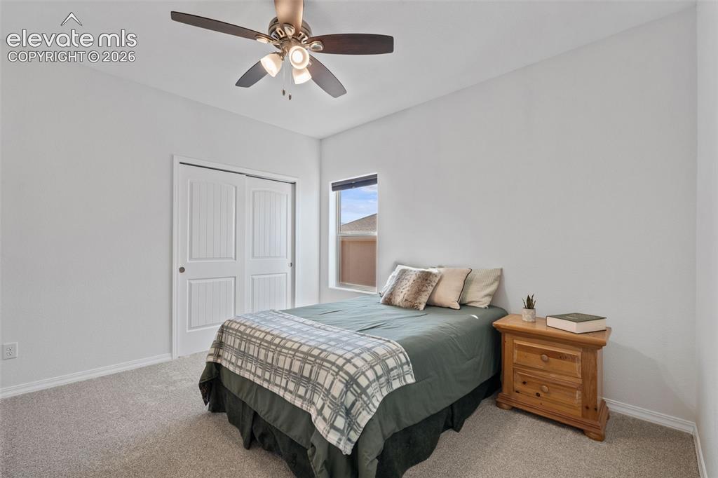 Image 33 of 50: Carpeted room featuring a ceiling fan with integrated lighting, a window, a