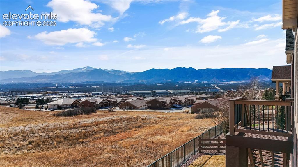Image 44 of 50: Expansive outdoor balcony with mountain scenery and distant residential dev
