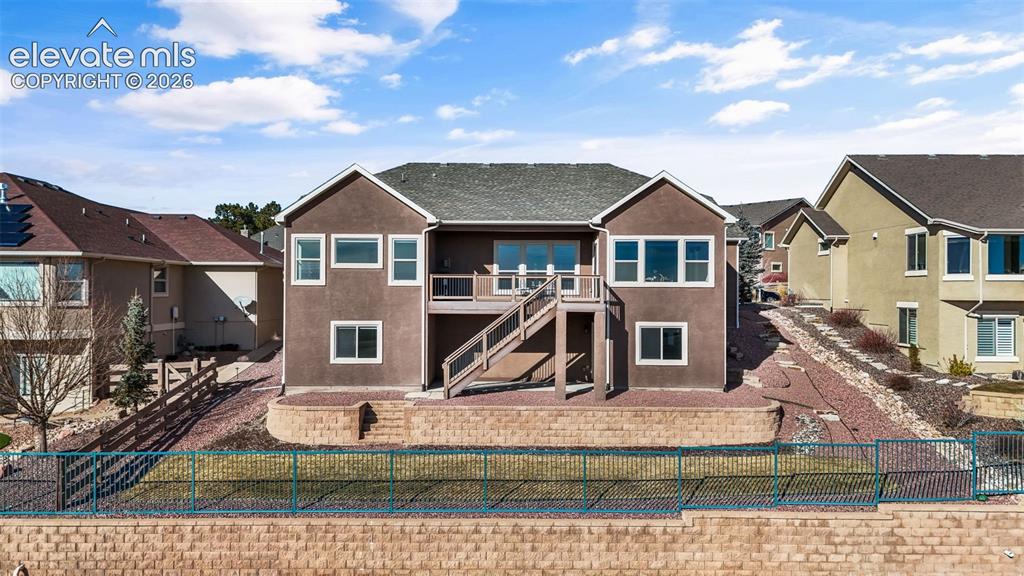 Image 45 of 50: Multi-level brown stucco exterior featuring an upper deck, lower patio, and