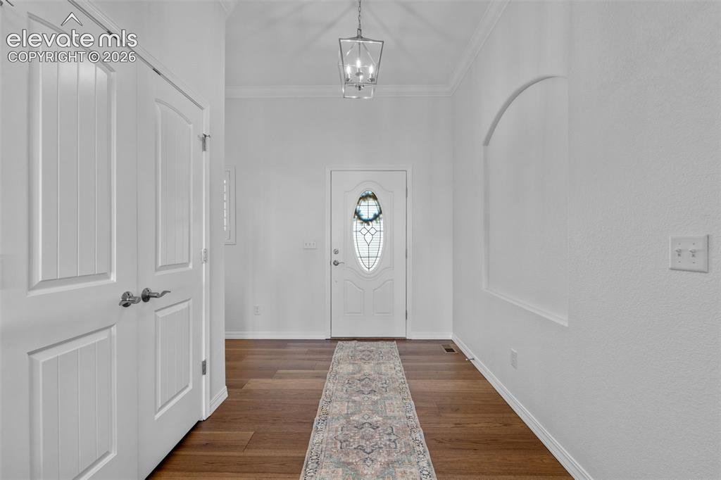 Image 6 of 50: Foyer featuring wood-finish flooring, a decorative front door with an oval 