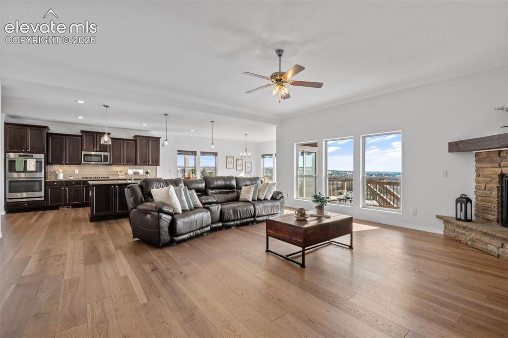 Image 8 of 50: Open-concept living area featuring wood-finish flooring throughout