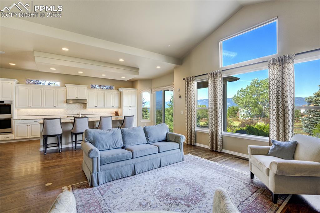 Image 9 of 50: Vaulted ceilings, a full wall of windows, and a stone fireplace with built-