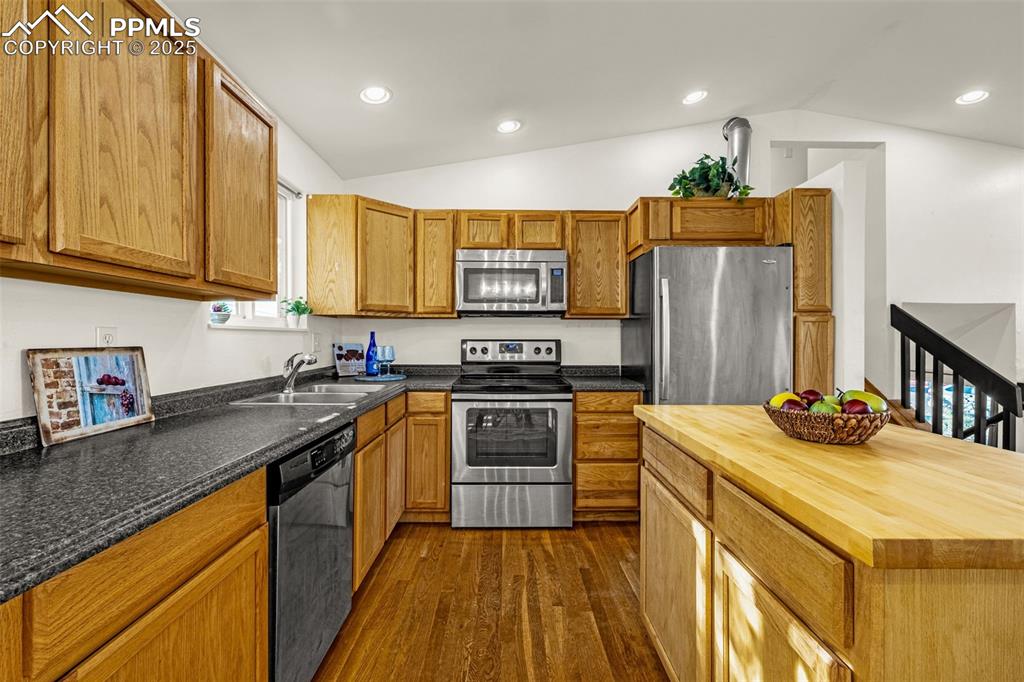 Image 10 of 33: Kitchen with appliances with stainless steel finishes, vaulted ceiling, but