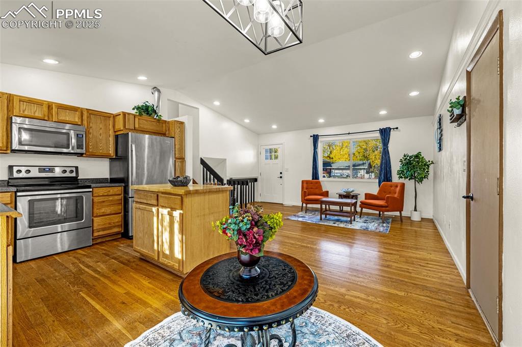 Image 7 of 33: Kitchen featuring stainless steel appliances, vaulted ceiling, dark counter