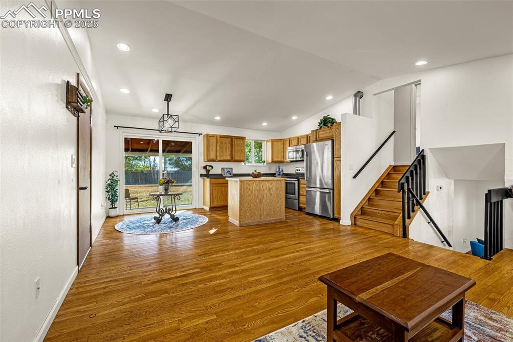 Image 8 of 33: Living area with recessed lighting, dark wood-style flooring, stairway, and