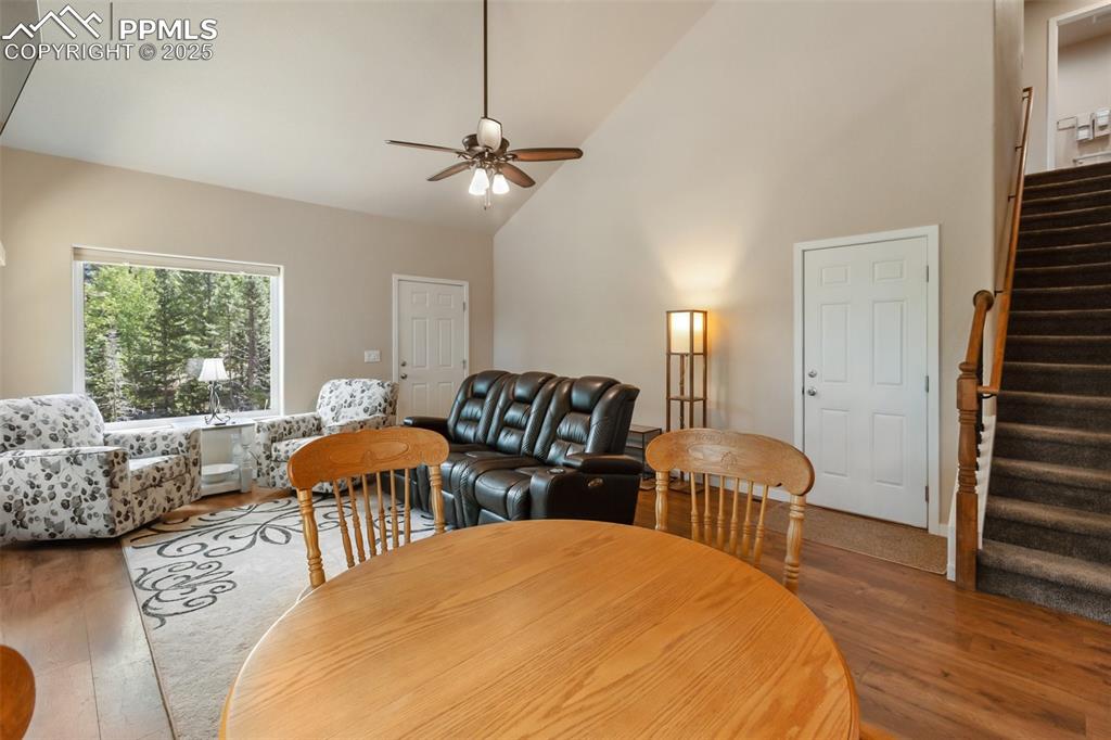 Image 27 of 46: Dining room featuring wood finished floors, stairs, ceiling fan, and high v