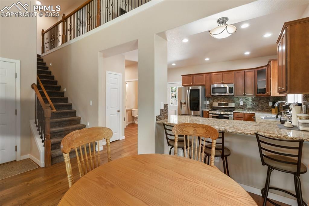 Image 28 of 46: Dining area featuring light wood finished floors, stairs, and recessed ligh