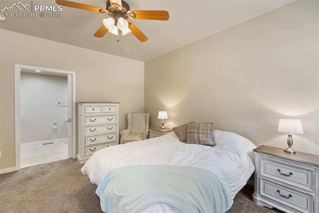 Image 29 of 46: Carpeted bedroom featuring ensuite bathroom and ceiling fan