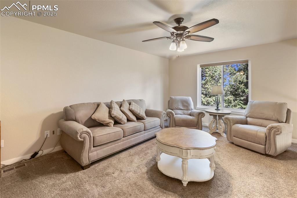 Image 35 of 46: Carpeted living area featuring ceiling fan and baseboards