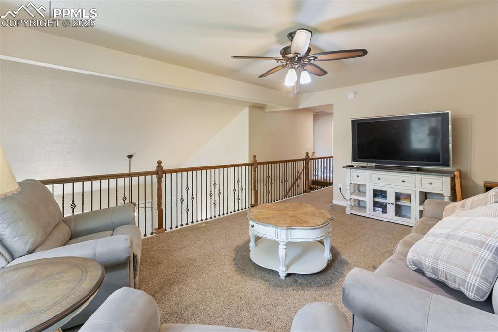 Image 36 of 46: Living room featuring a ceiling fan and carpet floors