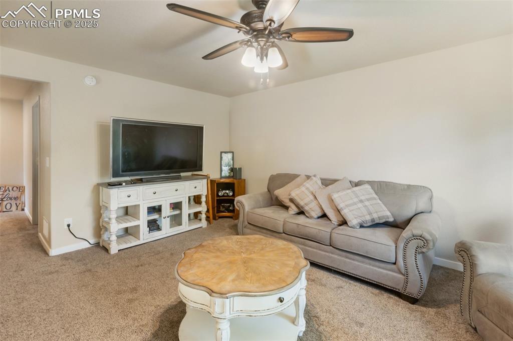 Image 38 of 46: Living area featuring carpet floors and a ceiling fan