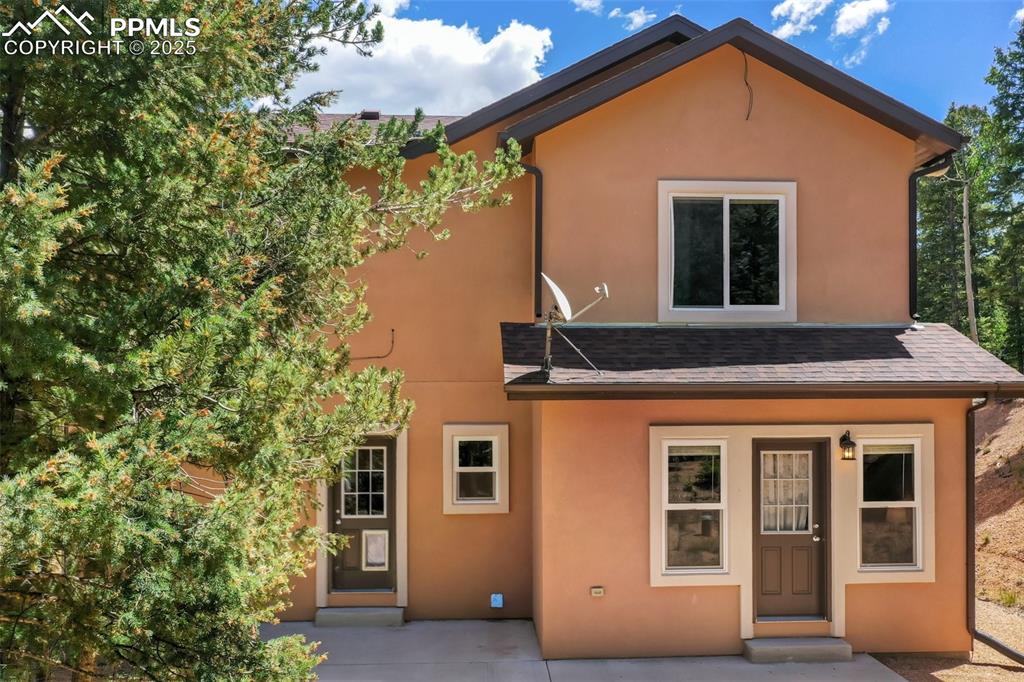 Image 4 of 46: View of front of house featuring stucco siding and a shingled roof