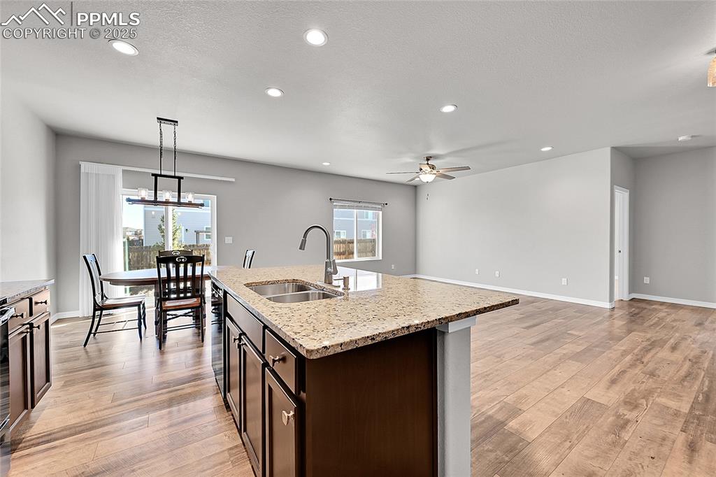 Image 11 of 43: Kitchen featuring dark brown cabinets, recessed lighting, decorative light