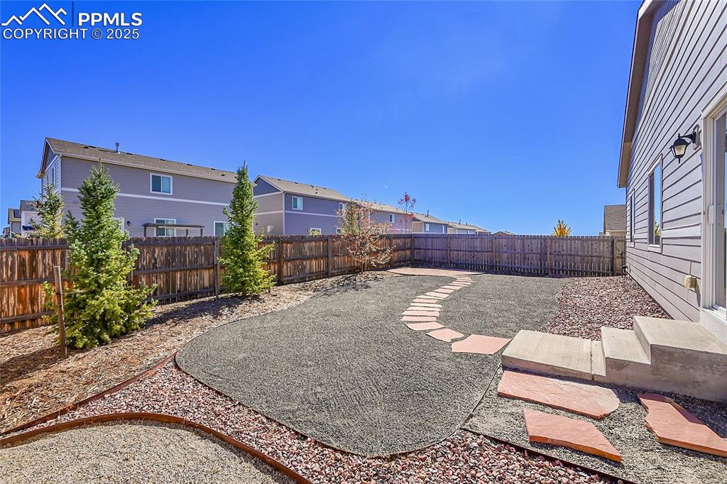 Image 27 of 43: Fenced backyard featuring a patio and drip system