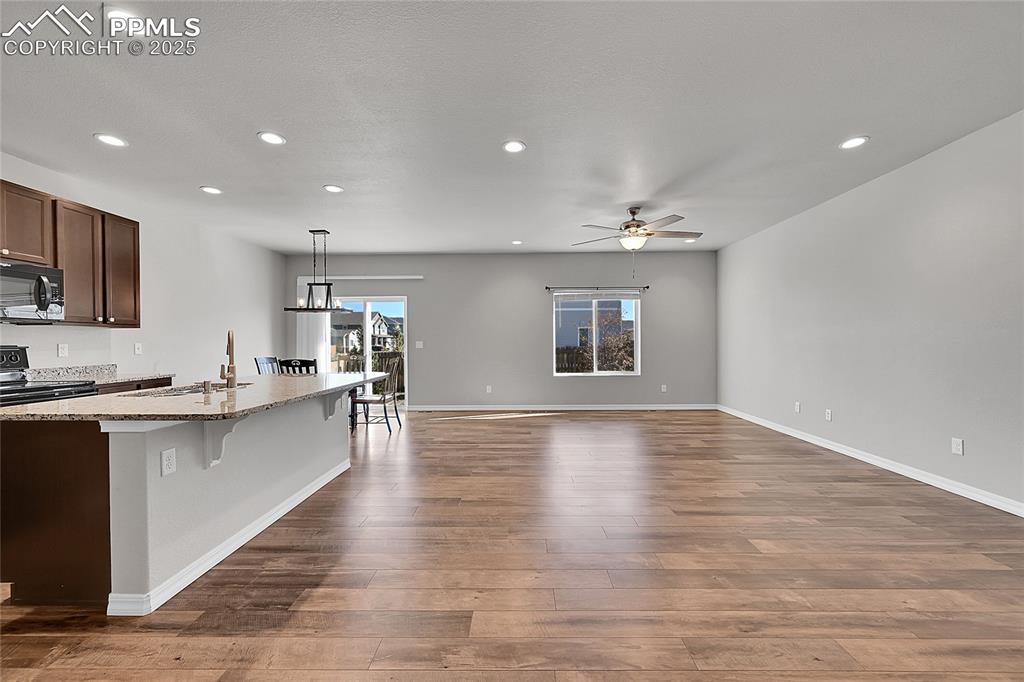 Image 4 of 43: Kitchen featuring a breakfast bar area, an island with sink, recessed light