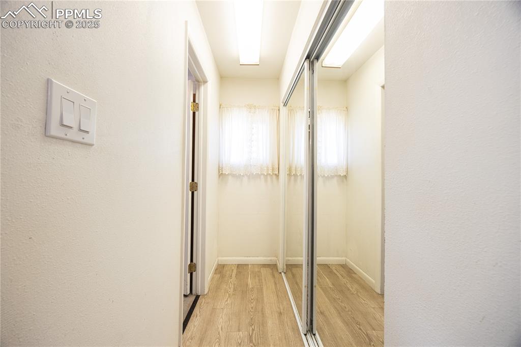Image 13 of 34: Hallway with light wood-style floors and a textured wall
