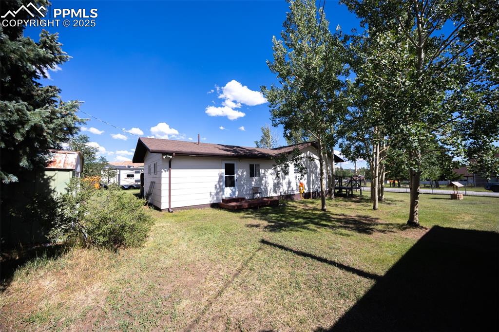 Image 19 of 34: Back of property featuring a yard