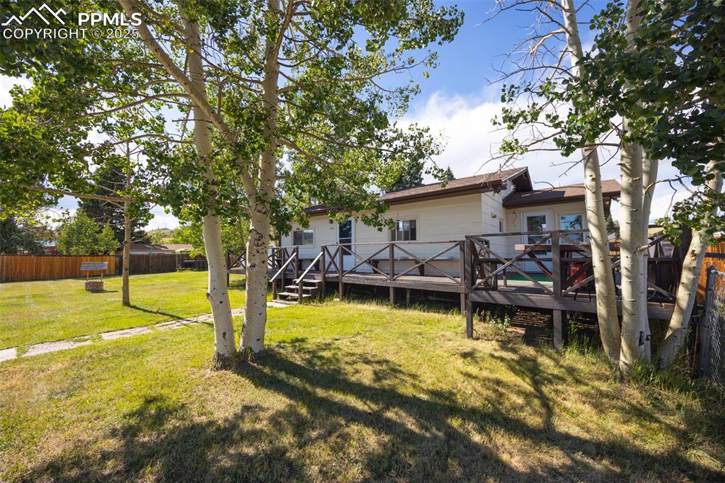 Image 2 of 34: Back of house featuring a fenced backyard and a deck