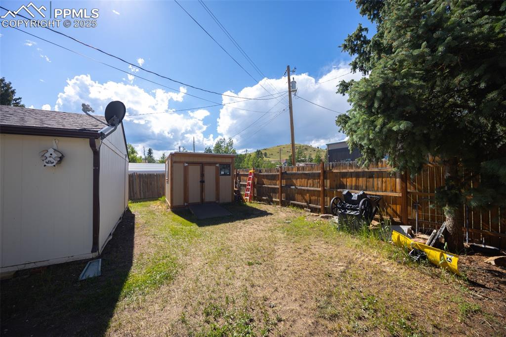 Image 21 of 34: Fenced backyard with a storage shed