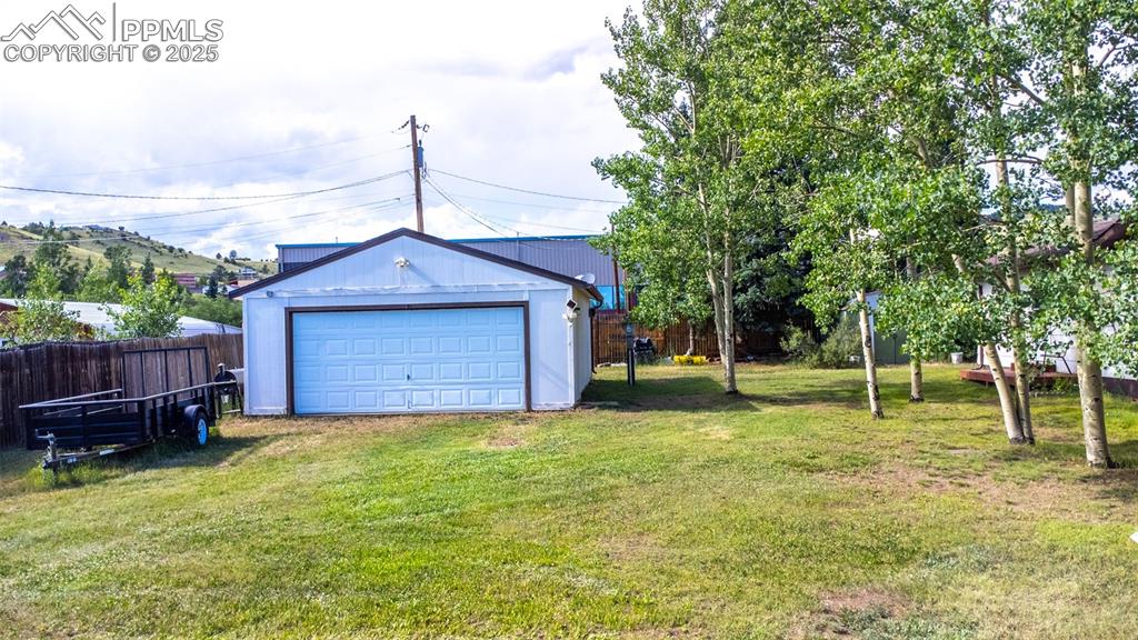 Image 25 of 34: View of yard featuring an outbuilding and a detached garage