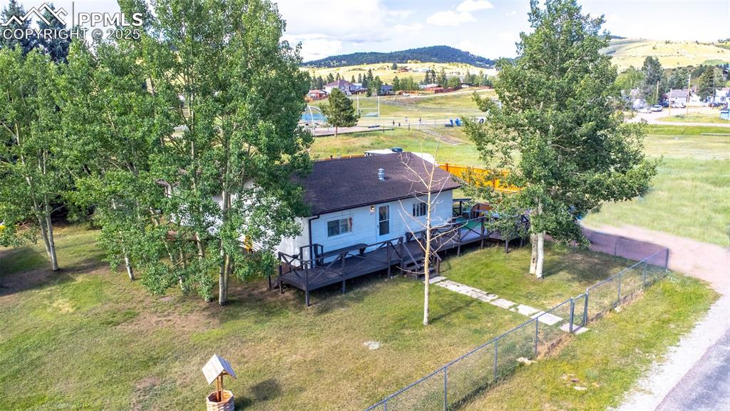 Image 26 of 34: Aerial view of property and surrounding area featuring a mountainous backgr