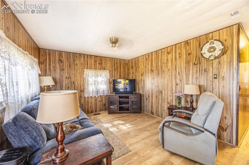 Image 5 of 34: Living room with wooden walls and wood finished floors