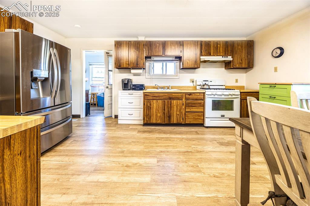 Image 6 of 34: Kitchen featuring stainless steel refrigerator with ice dispenser, white ga