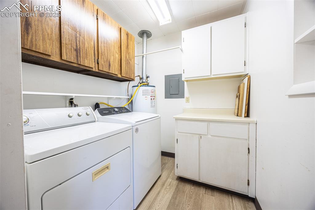 Image 8 of 34: Laundry room featuring washer and clothes dryer, light wood finished floors