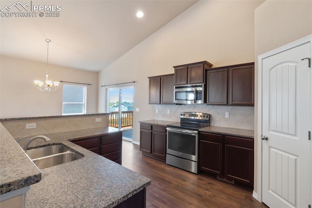 Image 11 of 45: Kitchen with dark brown cabinets, appliances with stainless steel finishes,