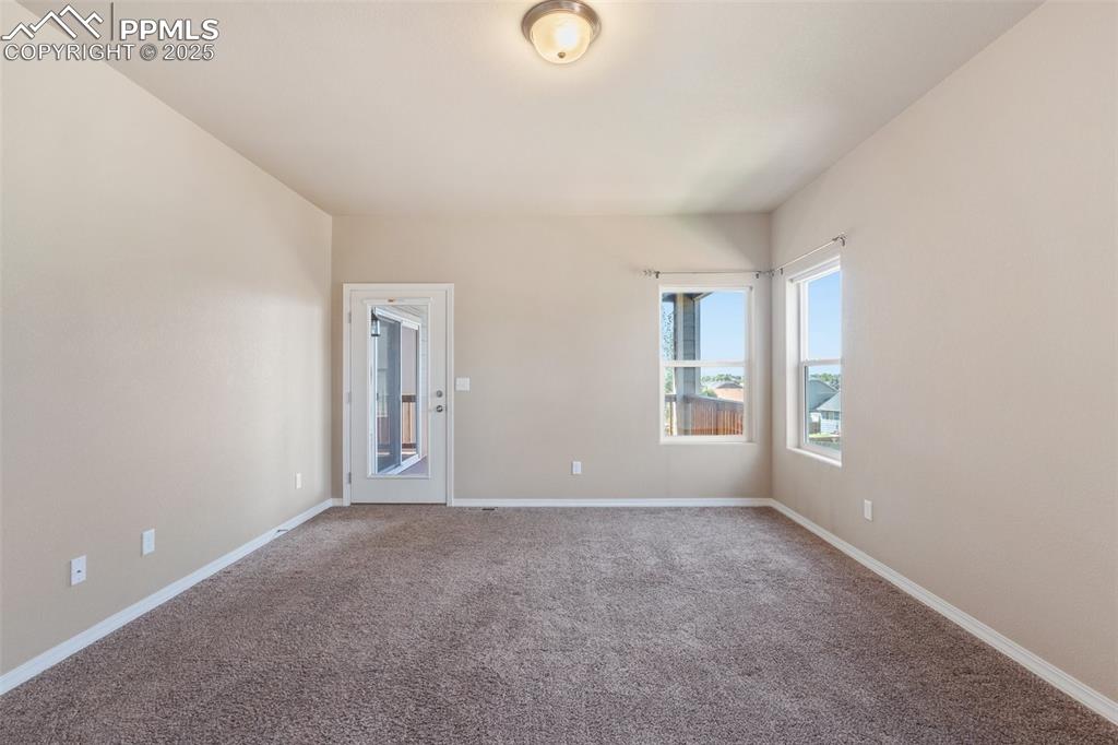 Image 15 of 45: Bedroom 2 on Main Level, Carpeted spare room featuring baseboards