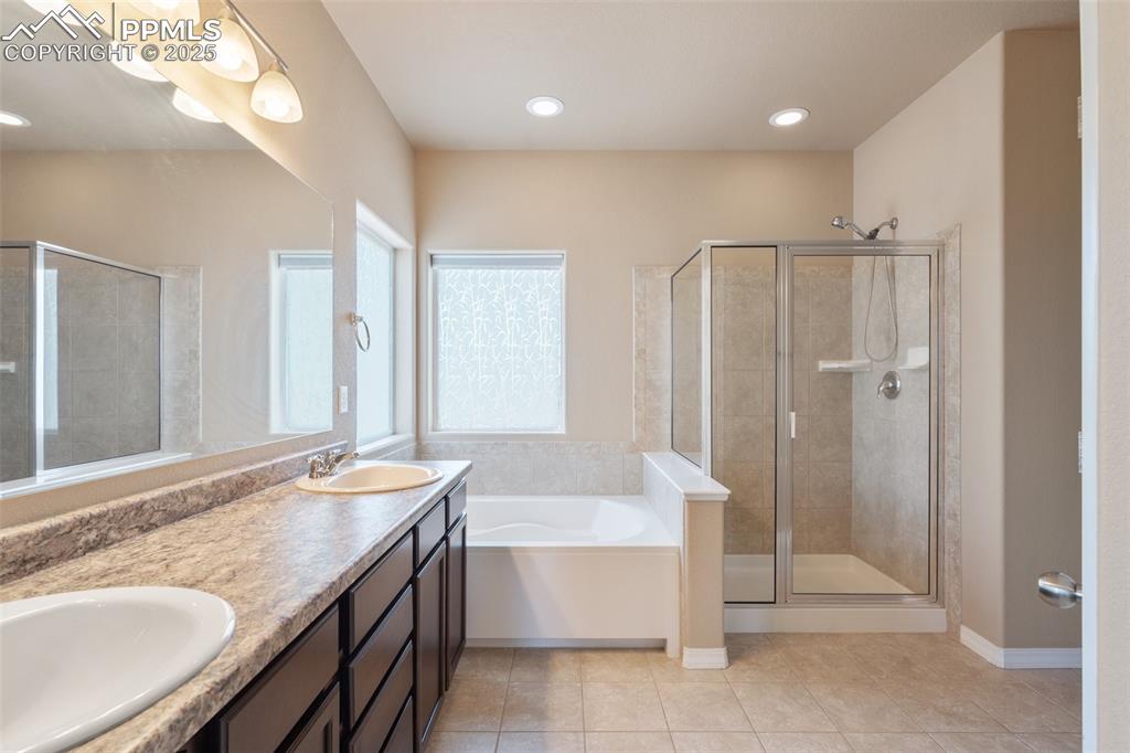 Image 18 of 45: Full bath with a bath, a stall shower, double vanity, light tile patterned