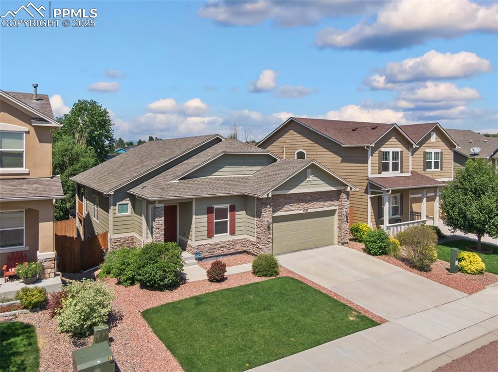 Image 2 of 45: Craftsman house with a shingled roof, stone siding, driveway, and a garage