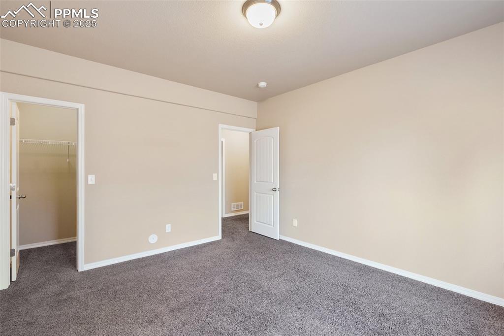 Image 28 of 45: Bedroom Basement Level - Unfurnished bedroom with a walk in closet and dark