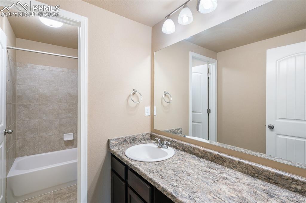 Image 35 of 45: Basement Full bathroom with vanity, shower / washtub combination, and light
